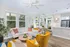 Bright, open-concept living area with modern decor, featuring a cozy sectional sofa, vibrant accent chair, and sleek kitchen with stainless steel appliances.