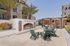 Luxurious outdoor patio with a cozy fireplace, elegant seating, and palm trees, perfect for relaxation and entertaining.Amenity building located at 1800 Santa Carolina Road in Chula Vista, California.