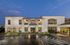 Elegant apartment complex at dusk featuring modern architecture, expansive windows, and ambient lighting.