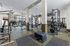 Modern fitness center equipped with state-of-the-art exercise machines, free weights, and a punching bag, set in a spacious, bright room with large windows offering a scenic view.Amenity building located at 1800 Santa Carolina Road in Chula Vista, California.