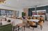 Luxurious open-concept private clubhouse with modern kitchen, elegant dining space, and cozy seating, overlooking a vibrant poolside view.Amenity building located at 1800 Santa Carolina Road in Chula Vista, California.