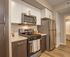 Modern kitchen with sleek stainless steel appliances, stylish cabinetry, and a cozy ambiance.