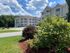 Well-maintained landscaping at Grassfields Commons in Dracut, Massachusetts featuring lush greenery, manicured shrubs, and inviting apartment buildings set under a clear blue sky