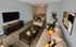 Spacious living room with sofa, coffee table, and accent chair flowing into dining area at Winchester Arms apartments in Dover, New Hampshire