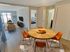 Dining area with modern table and chairs opening to living room and bedroom at Winchester Arms apartments in Dover, New Hampshire