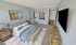 Bedroom featuring large bed, dresser, and walk-in closet access at Winchester Arms apartments in Dover, New Hampshire
