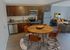 Modern kitchen with stainless steel appliances, wood cabinetry, and dining area in an open layout at Winchester Arms in Dover, New Hampshire