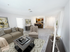 Inviting open-concept living area at Grassfields Commons in Dracut, Massachusetts featuring a cozy seating arrangement, soft neutral tones, and a seamless flow into a kitchen with breakfast bar seating