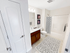 Clean and spacious bathroom at Grassfields Commons in Dracut, Massachusetts featuring a full tub and shower and large vanity with storage