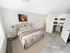 Spacious bedroom at Grassfields Commons in Dracut, Massachusetts featuring plush carpeting, elegant furnishings, and an open walk-in closet