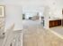 Expansive open-concept layout at Grassfields Commons in Dracut, Massachusetts showcasing a seamless connection between dining, kitchen, and living areas with soft carpeting and an airy, comfortable feel