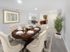 Tastefully designed dining area at Grassfields Commons in Dracut, Massachusetts featuring a large table with seating for six, soft carpeting, and an open view leading toward the kitchen