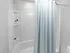 Bathroom with tub and shower combination and built-in shelving in an apartment at Westgate Arms in Salem, New Hampshire