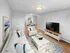 Spacious living room with open layout, hardwood-style flooring, and dining area in a staged apartment at Westgate Arms in Salem, New Hampshire