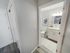 Bathroom at Hamilton Park in Methuen, Massachusetts featuring a single-sink vanity, modern lighting, and adjacent hallway access