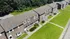 Aerial view of brick townhome-style residences with private entrances, sidewalks, and landscaped green space at Meadowbrook Village in Gardner, Massachusetts