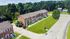 Aerial view of brick townhome-style buildings with private entrances, sidewalks, and open green lawn areas at Meadowbrook Village in Gardner, Massachusetts