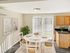 Dining area with sliding glass door, natural light, and adjacent kitchen at Meadowbrook Village in Gardner, Massachusetts