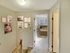 Carpeted upstairs hallway with wall decor and doorway leading to bedroom at Meadowbrook Village in Gardner, Massachusetts