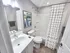 Modern bathroom with elegant fixtures, stylish artwork, and a chic white shower curtain, showcasing a pristine and inviting ambiance.