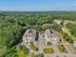 Aerial view of Grassfields Commons in Dracut, Massachusetts showing residential buildings, parking areas, and surrounding wooded landscape