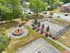 Aerial view of Manchester Gardens showing a fenced sports court, landscaped courtyard with a central fountain feature, and surrounding walking paths
