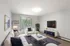 Living room with large sliding glass door leading to a private balcony, wall-mounted air conditioning unit, and open floor plan