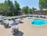 Relaxing outdoor pool area with lounge seating and umbrellas at Derry Country Club Estates in Derry, NH