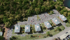 Aerial view of Winchester Arms apartments in Dover, New Hampshire featuring residential buildings, parking areas, and surrounding wooded landscape
