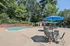 Outdoor pool and shaded patio seating at Woodlands at Nashua apartment community in Nashua, NH