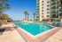 Apartments Downtown Jacksonville FL - The Strand - Resort-Style Pool with Sun Lounge Chairs, Palm Trees, and City View