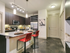 Modern kitchen with pendant lighting, island, wine rack, stainless steel appliances and concrete flooring