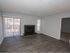 living room with grey painted walls and white trim, fireplace wood floors and vertical blinds to balcony