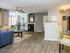 Open living room with wood inspired plank flooring, fireplace and ceiling fan
