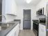Kitchen with granite countertops in kitchen, faux wood flooring and white tile backsplash