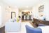 Beautiful furnished model living room with wood inspired plank flooring and view into kitchen