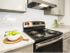 Close up view of kitchen oven/stove, granite countertops and tile backsplash