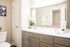 Renovated bathroom with shaker style neutral cabinets with pulls, quartz cabinets and framed mirror