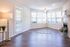 View into living room with 6 windows, fireplace with tile surround and plank wood inspired flooring