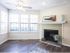 View into living room with 6 windows, fireplace with tile surround and plank wood inspired flooring