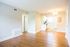Remodeled vintage living room with plank flooring looking into the kitchen