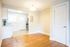 Remodeled vintage living room with plank flooring looking into the kitchen