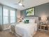 Ridgelake, interior, bedroom, green accents, white bed, carpet, two windows, ceiling fan