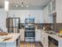 Ridgelake, interior, kitchen, breakfast bar island, wood floor, stainless steal appliances, refrigerator, stove/oven, microwave, dishwasher, white cabinets, high ceilings