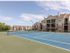 tennis court with apartments behind