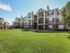 large lawn with beige and tan apartment building