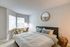 The Henry Apartments, interior, bedroom, spacious, large bed, natural light, windows, carpet, round mirror, seating area