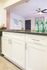 White Kitchen Cabinets with brushed nickel hardware and faux wood flooring