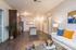 San Mateo Apartments Kissimmee Florida open living area adjacent to kitchen with vinyl plank flooring, wood cabinets, pendant lights, granite counters, and stainless appliances