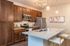 San Mateo Apartments Kissimmee Florida island kitchen with stainless steel appliances, granite counters, undermount sink in island, pendantand track lights, and vinyl plank flooring